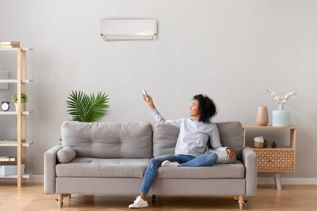 Woman turning on air conditioner